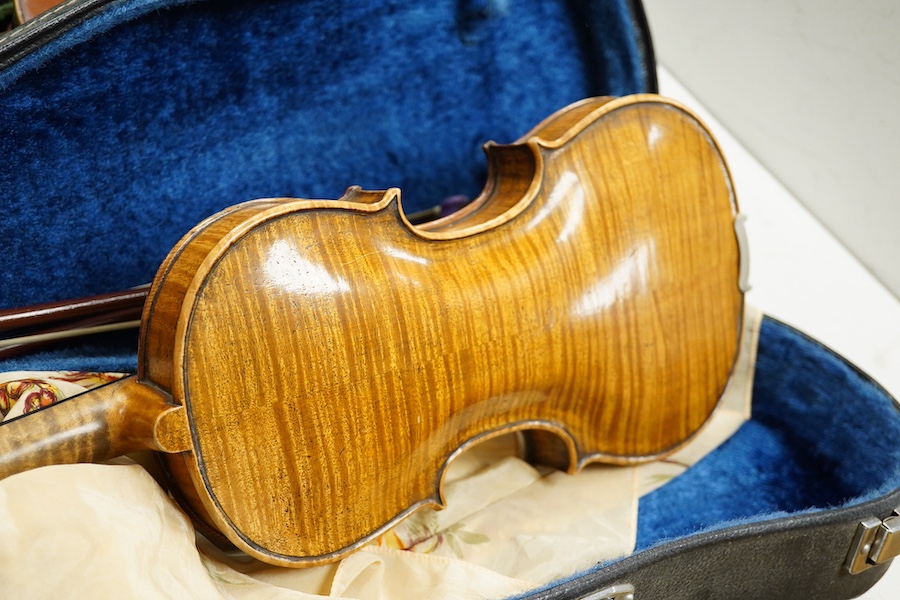 Four cased violins; an early 20th century violin, body 36cm, fitted with a microphone pick up taking a quarter inch jack plug, an early 20th century half size violin, body 32cm, and two student violins. Condition - poor